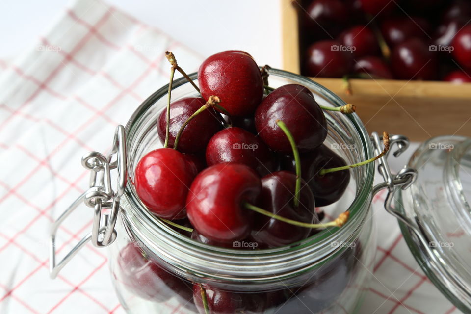 Close-up fresh cherries in glass jar