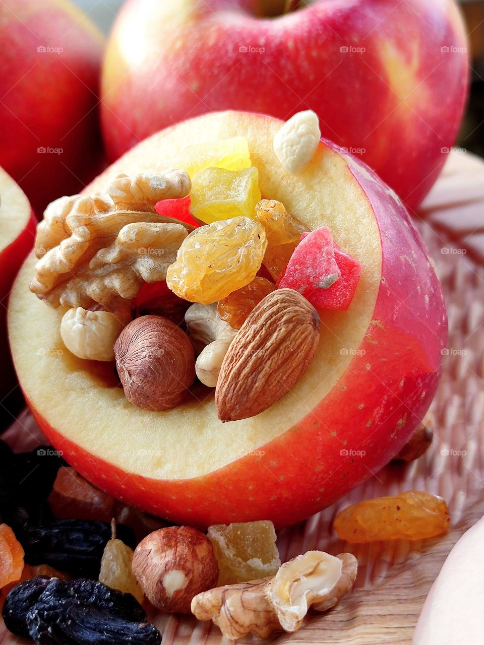 An apple with a mixture of nuts and dried fruits inside
