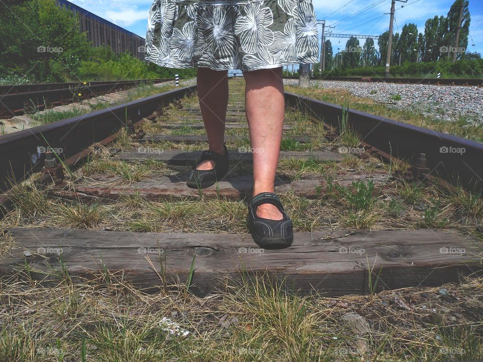 female feet on railway tracks