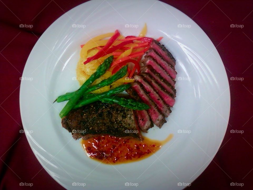 Steak Dinner . Medium rare steak, saffron rice and asparagus with a sweet chili sauce 