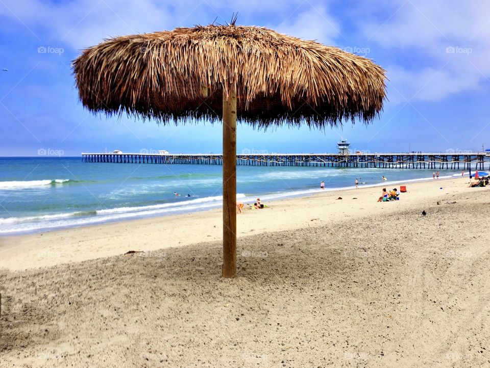 Foap Mission “I Love This Photo”! Palapa Umbrellas On The Beach With The pier In the Background!