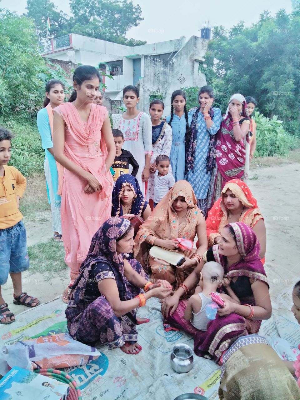 Here in this photo there is a small crowd because of a ritual is being done.
In which the hair of small child is cut .It is called 'Shubh Mundan Sanskar'.