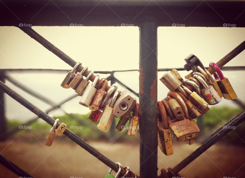 Padlocks grouped together on a railing