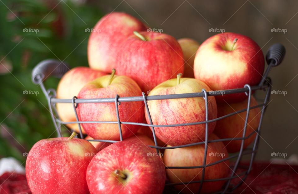 Fruits - apples in a wire basket on red bandana-print fabric