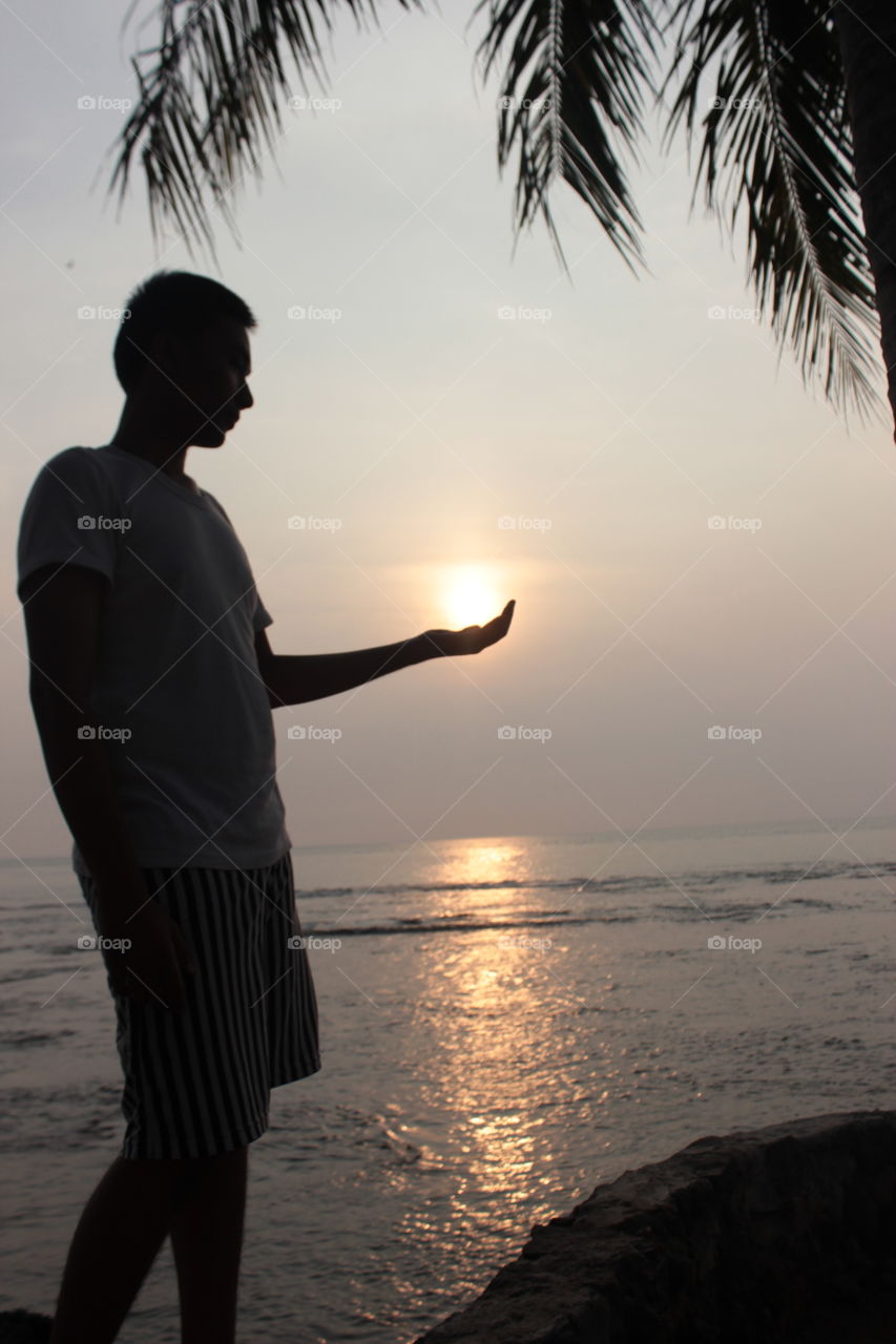 took this picture of a friend who is puttnling the sun in the palm of his hand