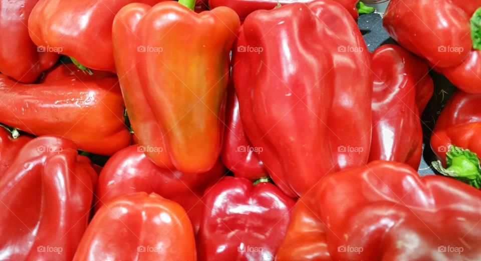 Red capsicums or bell peppers on display in a local market.