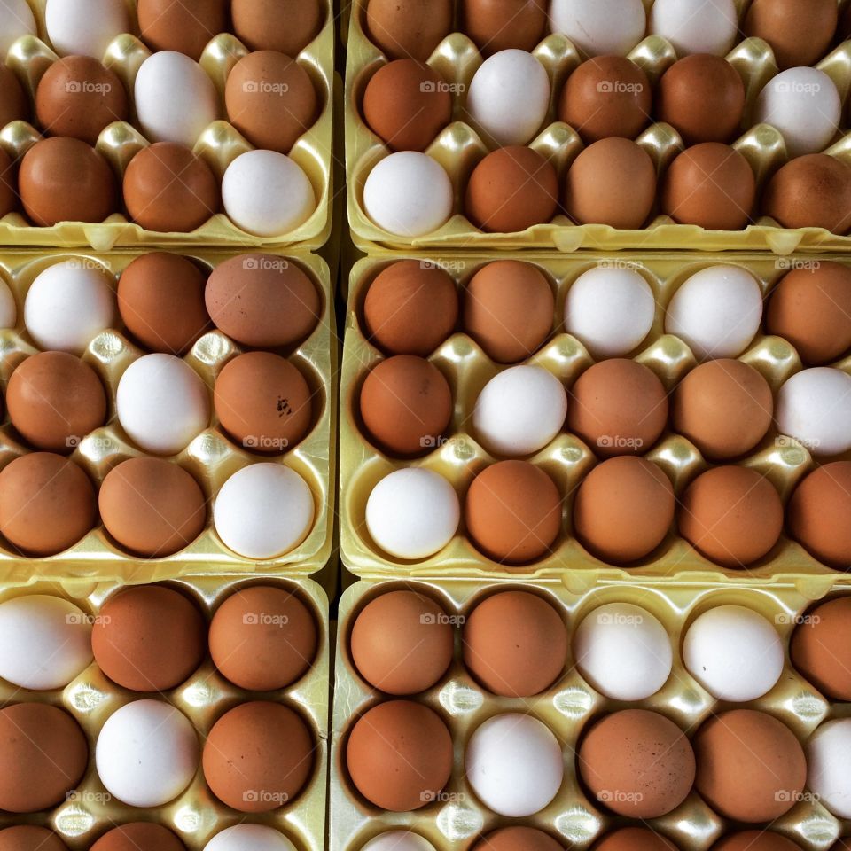 Eggs at the market, colorful and fresh, waiting in neat little rows, all shades of brown and white