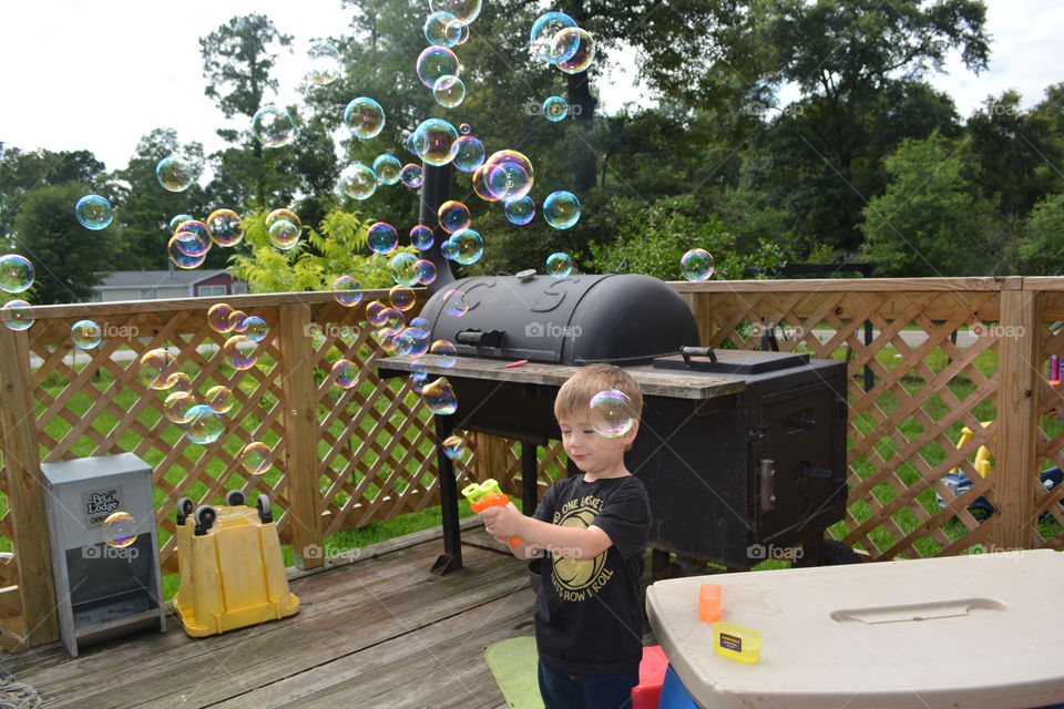 Grandson playing with bubbles on our front porch