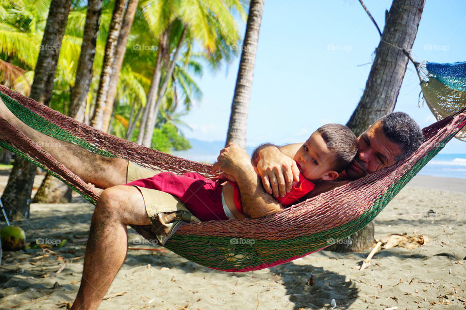 Father and son enjoying of the summer in the beach