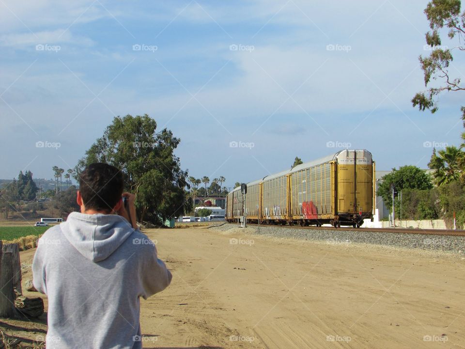 A fellow railroad enthusiast photographs the rear end of a Southbound freight train 