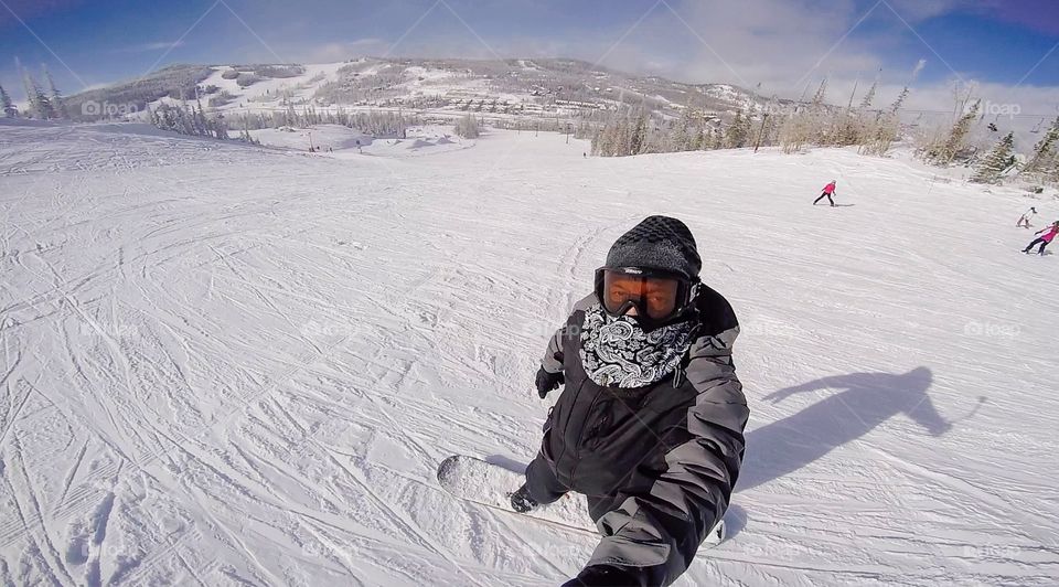 Guy enjoining snowboarding 