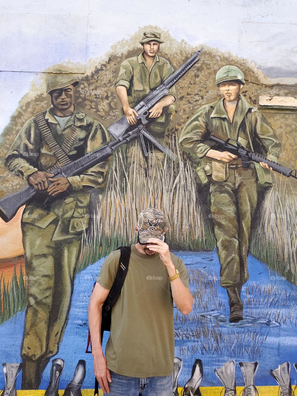 A Veteran in front of a Vietnam art mural in remembrance of Vietnam veterans.