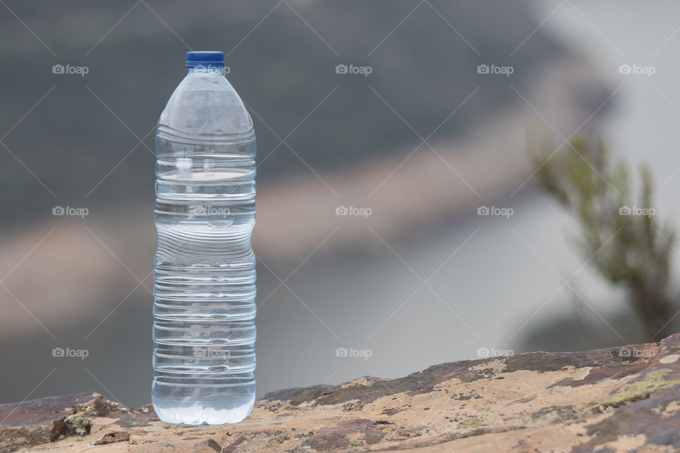 Water bottle standing on rock