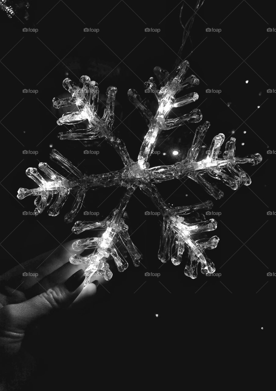 Hand holding snowflake shaped christmas lamp