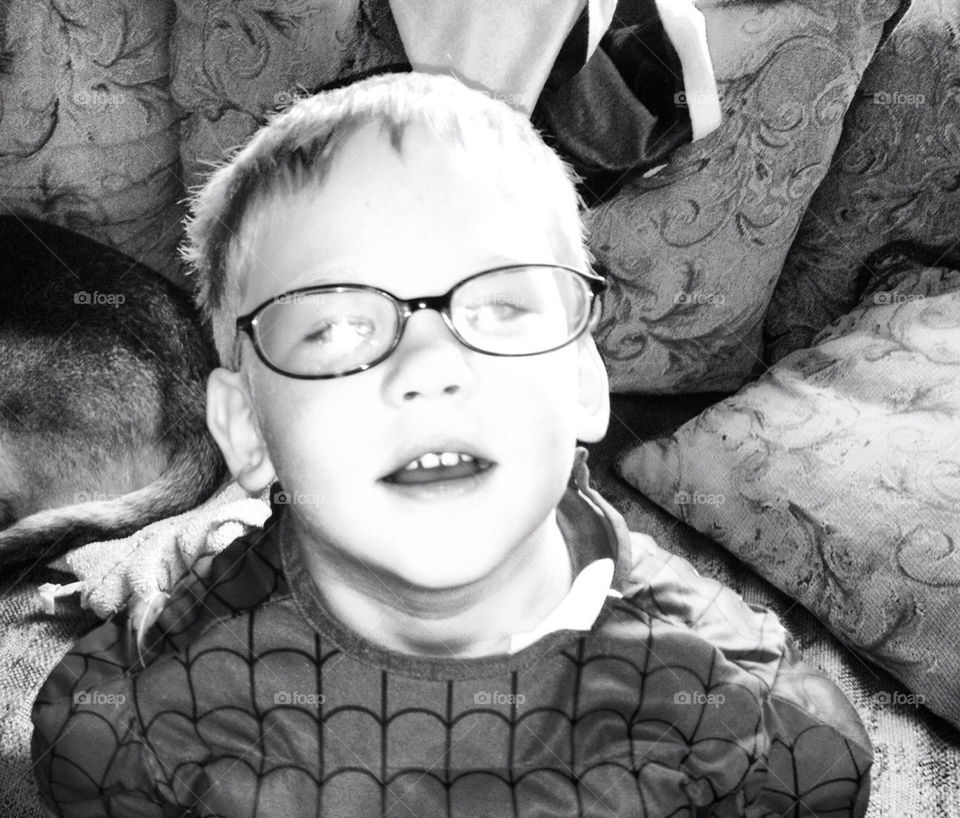 Young boy wearing glasses looking up with joy