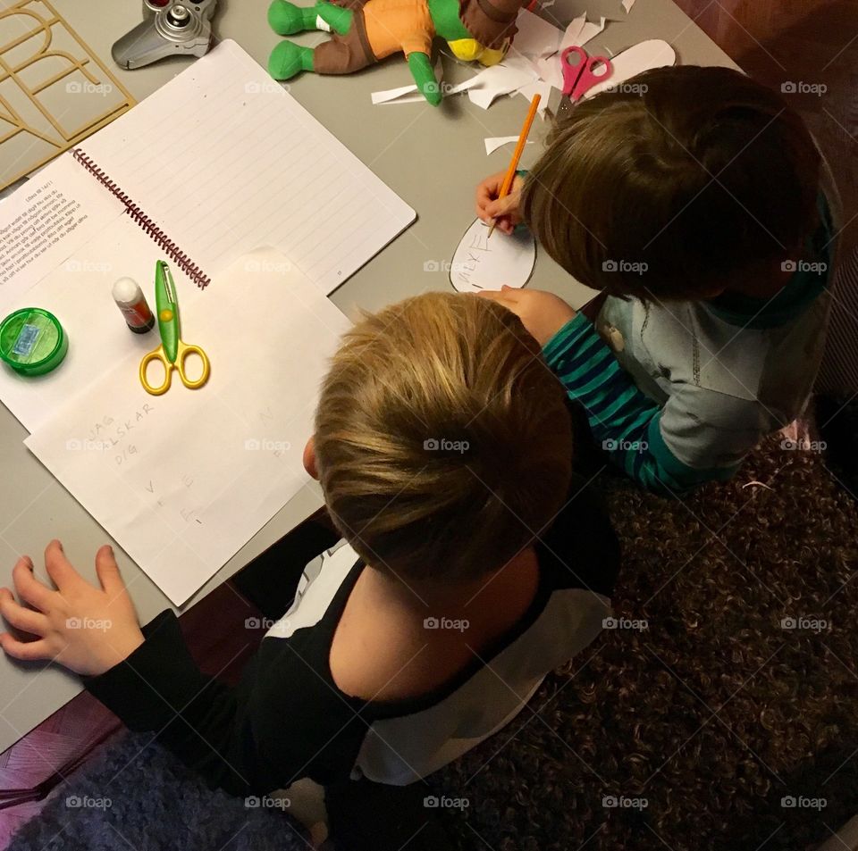 Two brothers doing homework, from above