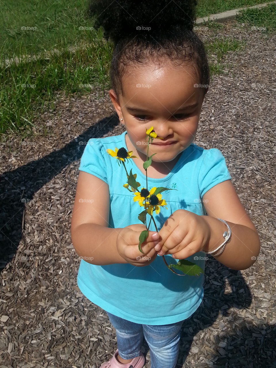 Made a new Friend. While at the playgr ound, a fellow two year old gave Carmen these flowers in exchange for Carmen's yellow bouncy ball.