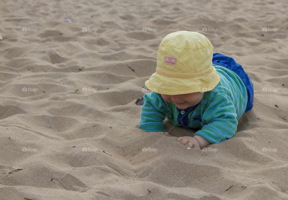 Baby crawling in the sand on the beach