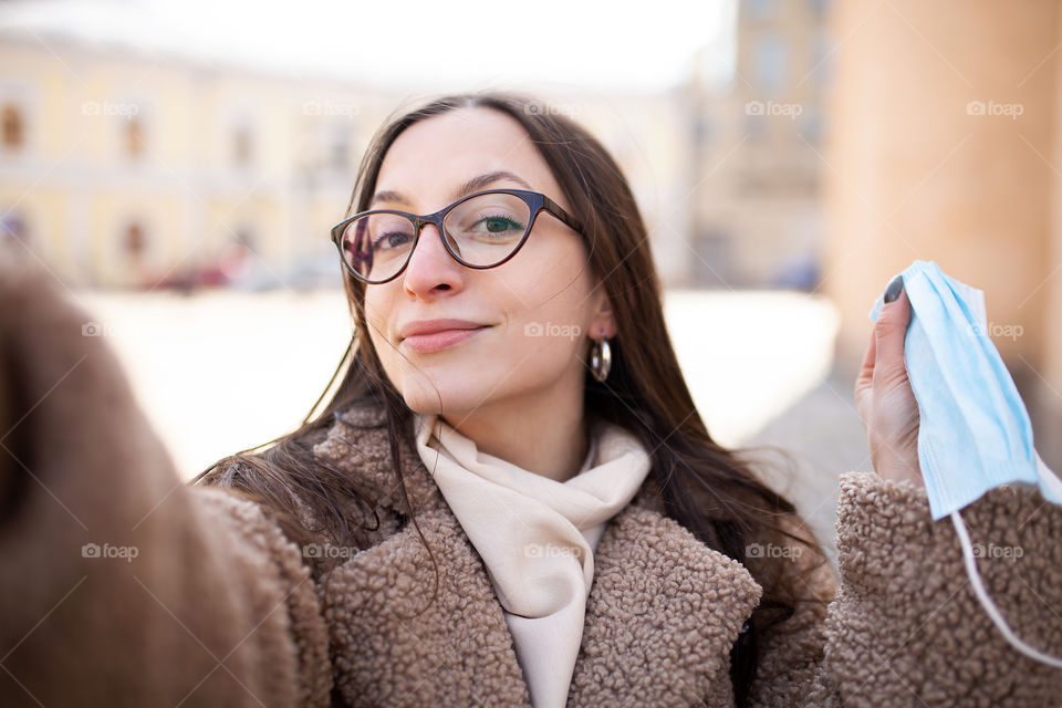 young woman holding a mask in her hand