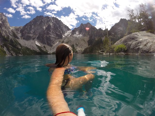 Person swimming in alpine lake