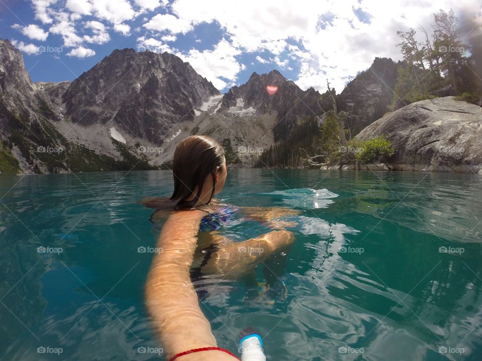 Person swimming in alpine lake