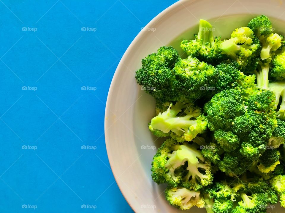 broccoli in a plate on a blue background