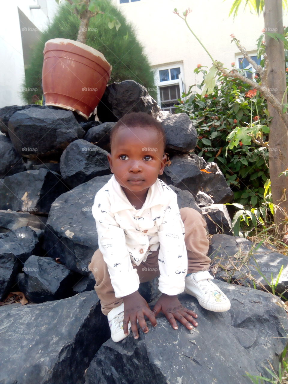 My son looking at the camera in wetlands park and garden, besides the main hall window.