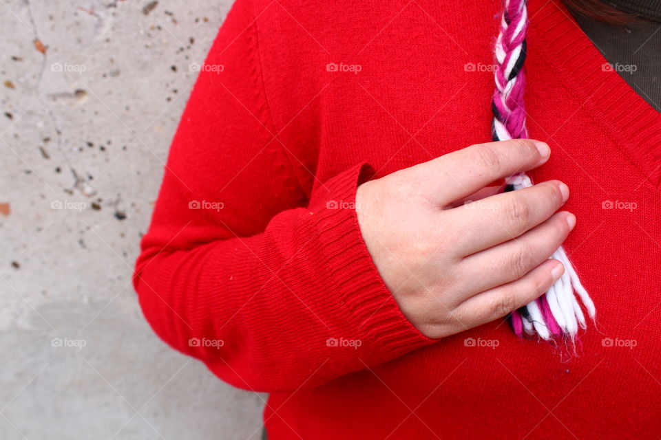 Girl with red pullover with hand on gray background