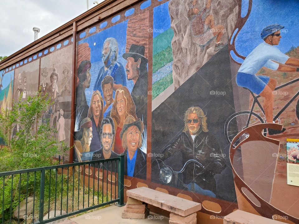 A building features numerous murals on the outside wall