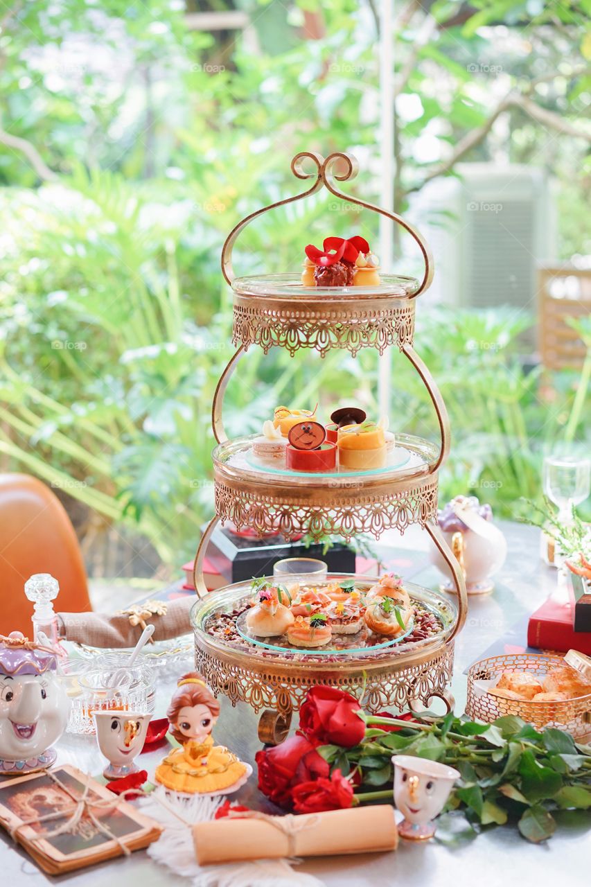 BKK - Oct 12, 2019 : An afternoon tea oarty in a fairytale concept inspired from Beauty and the Beast movie (2017) with soft focus on the cogsworth dessert on the 2nd tier.
