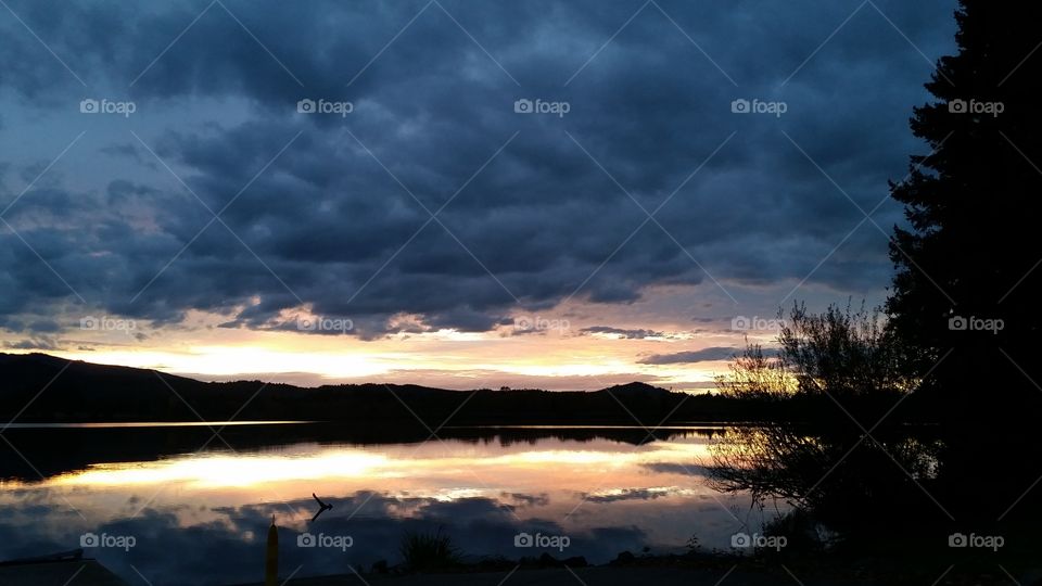 cloud shot Sunset with dramatic clouds reflected in lake