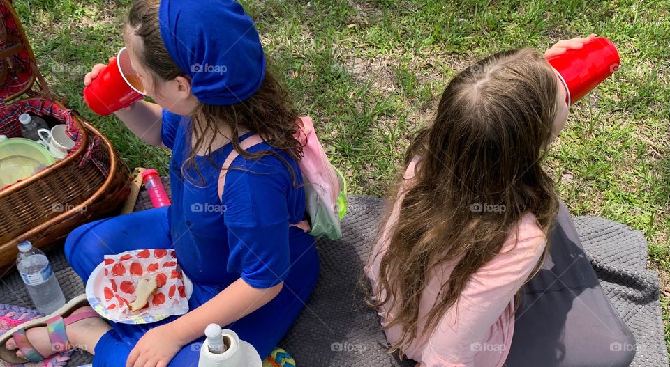 Picnic Basket Opened Up With Food And Items Needed For The Picnic Meal As A Family With Our Girls Excited To To Eat And Enjoy In The Urban Nature, Drinking Their Cups Of Apple Juice Together.