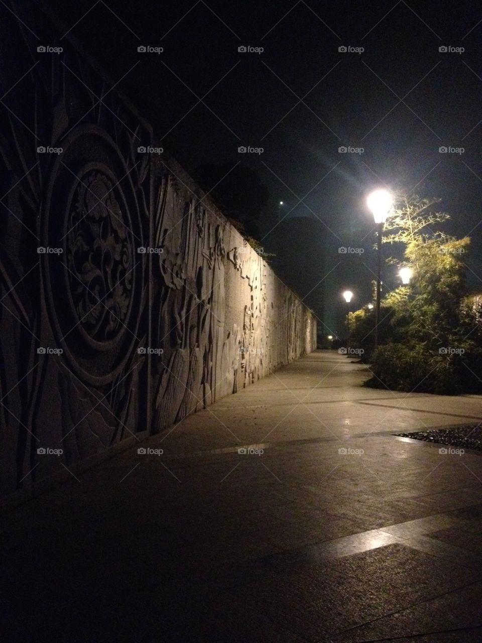 A passage with a historic plot on a concrete wall in the night 