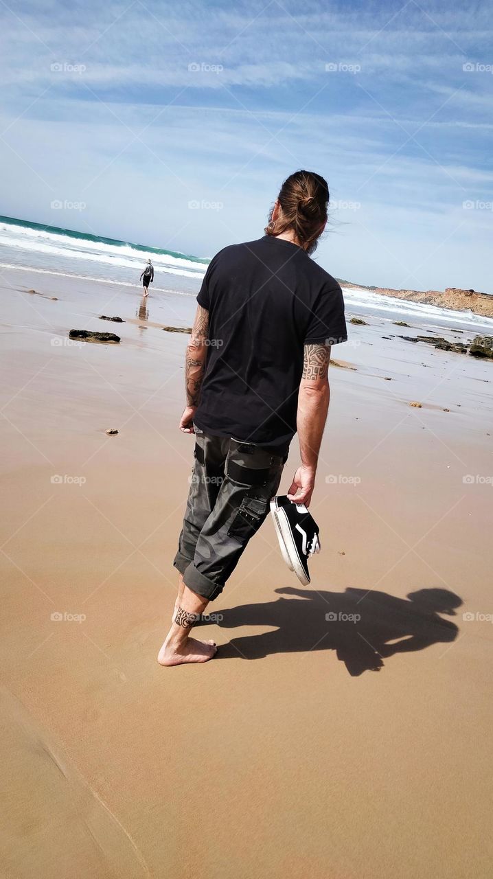 man at the beach barefoot