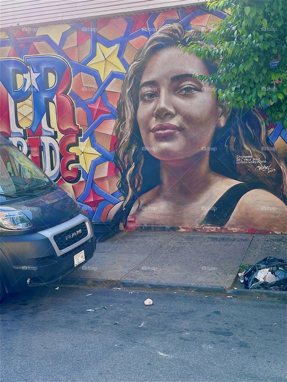 The smiling Latina next to the words “PR” and “PRIDE” is part of a mural on “Jefferson St” by “B’way” & “Myrtle Ave” in “Bushwick”, Bklyn that is almost an entire city block long next to the club restaurant “La Lupe”. 2024. Hypnotic Productions