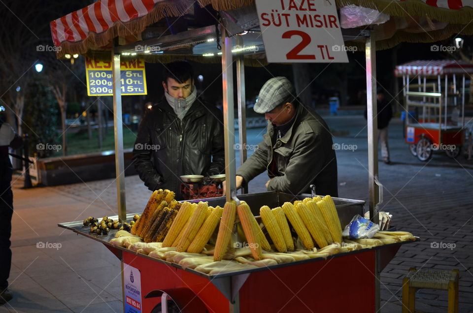 Person selling corn at stall