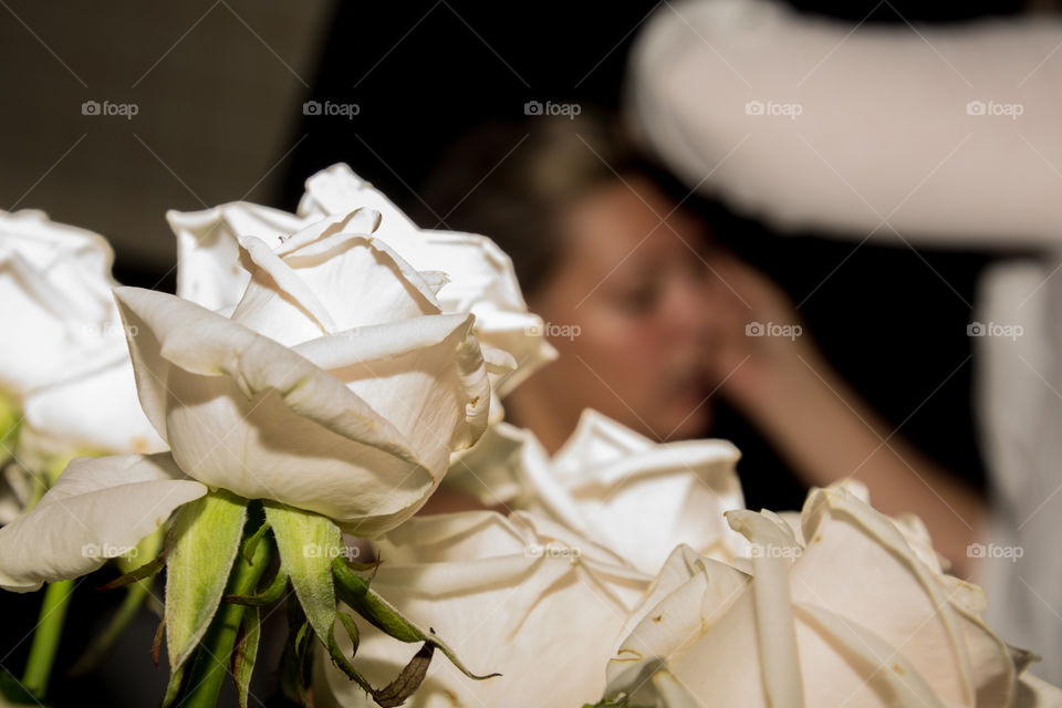 White roses with bridal make-up in the back ground 