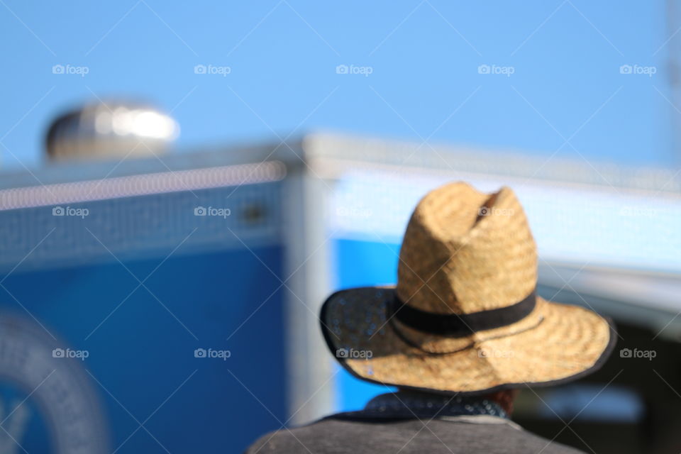 Back head shot man wearing straw brimmed hat outdoors blurr d background 