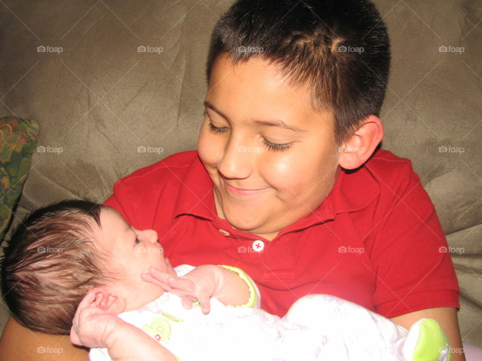 Big brother holding newborn sister
