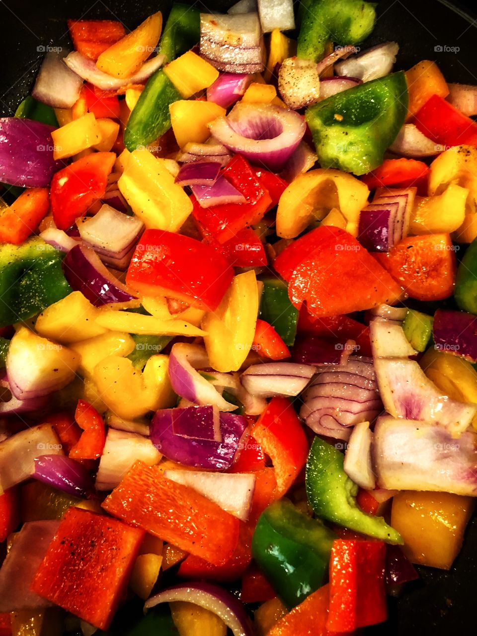 Clash of colors chopped and cooking red yellow green bell peppers and purple onion meal prep 