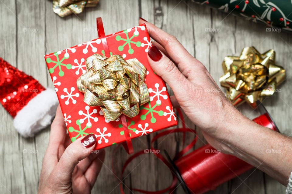 Woman's hands are holding beautiful box with a Christmas present