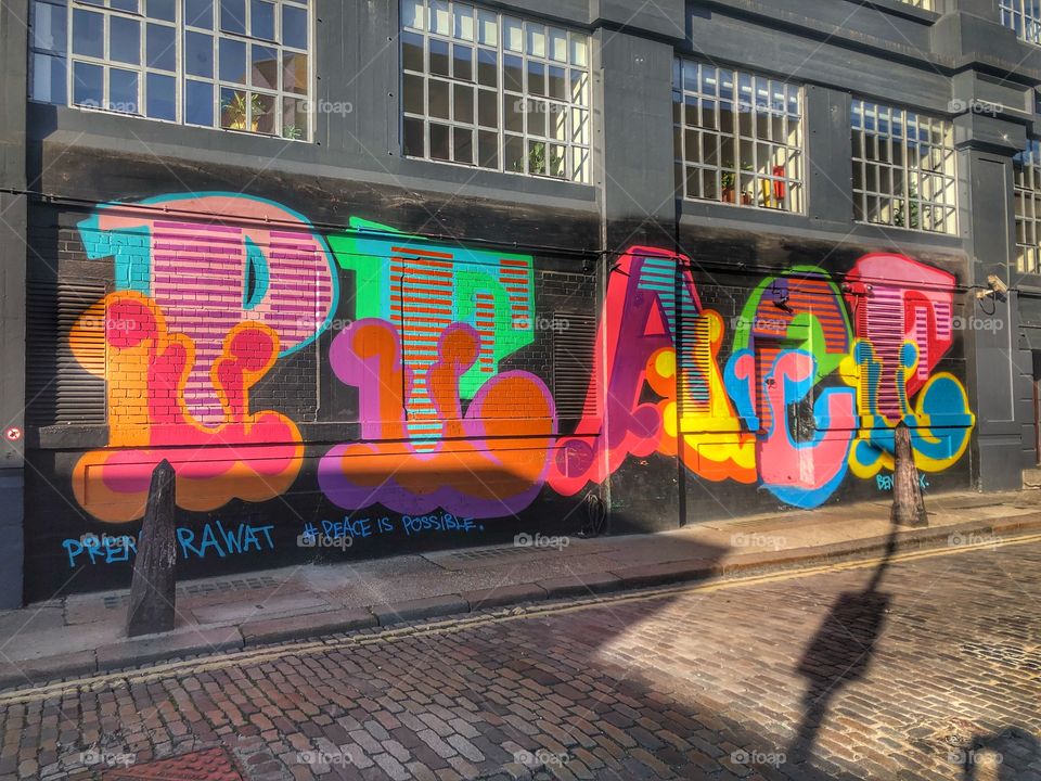 Ben Eine colourful peace mural on building exterior in London, england