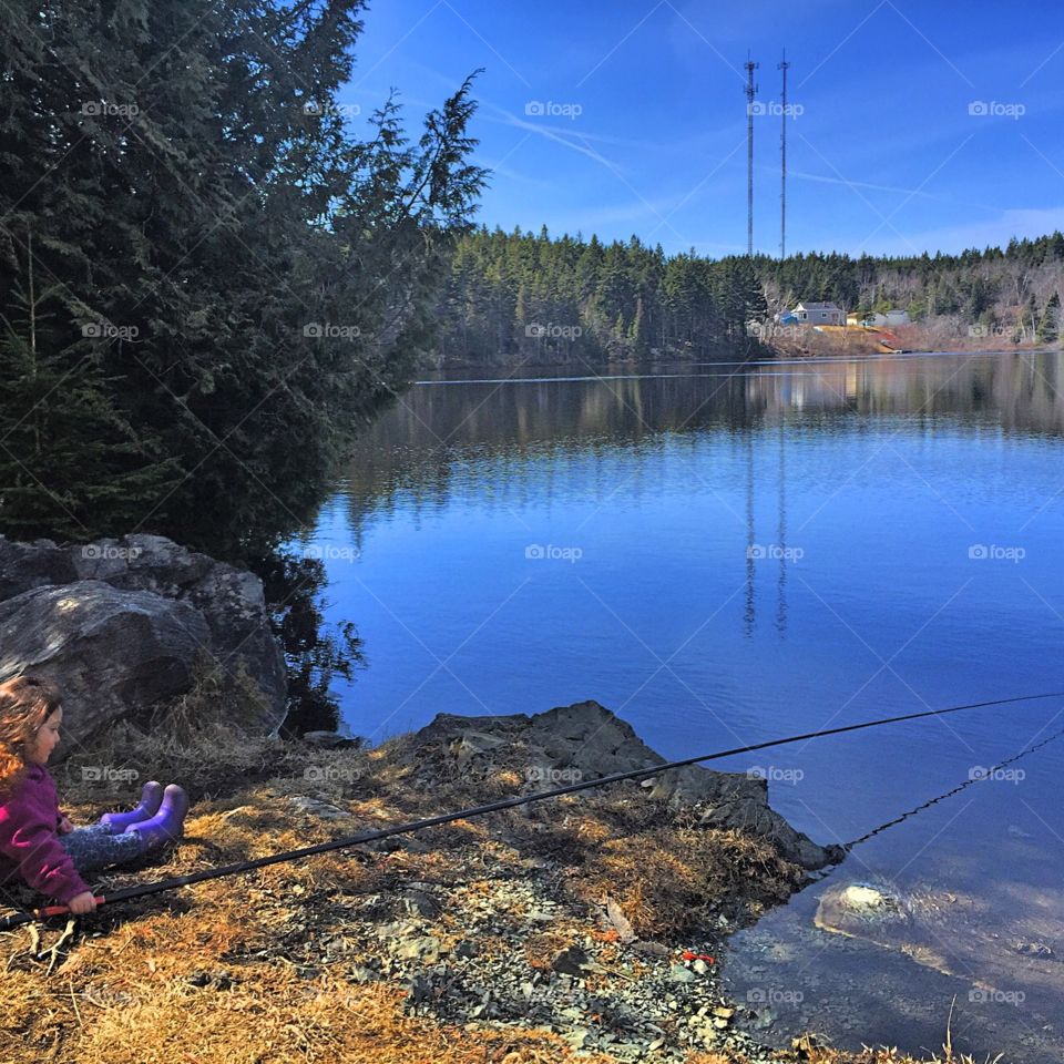 Little girl fishing in a Canadian lake in New Brunswick.