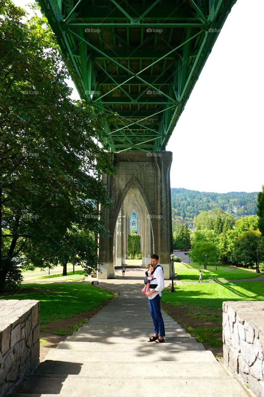 Father carrying his daughter in baby carrier at park