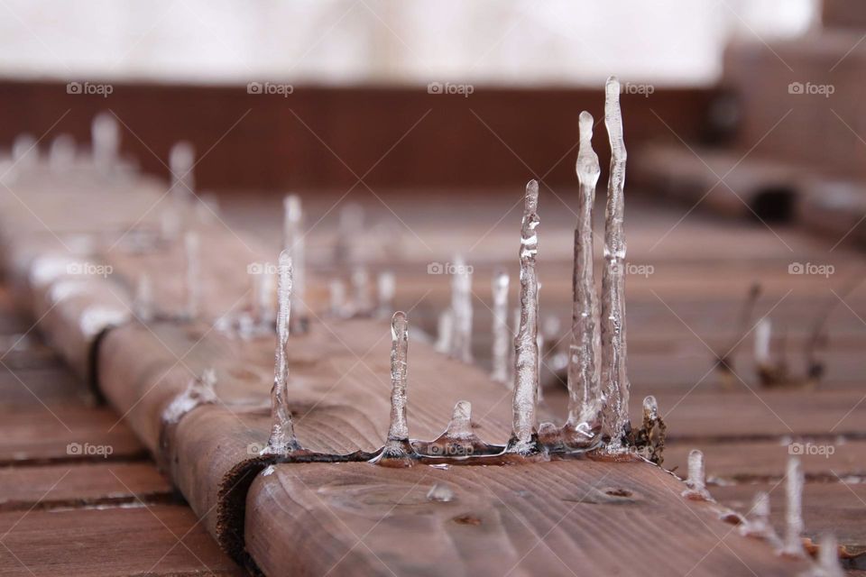 Icicles hang from wooden deck and flipped to create frozen stakes