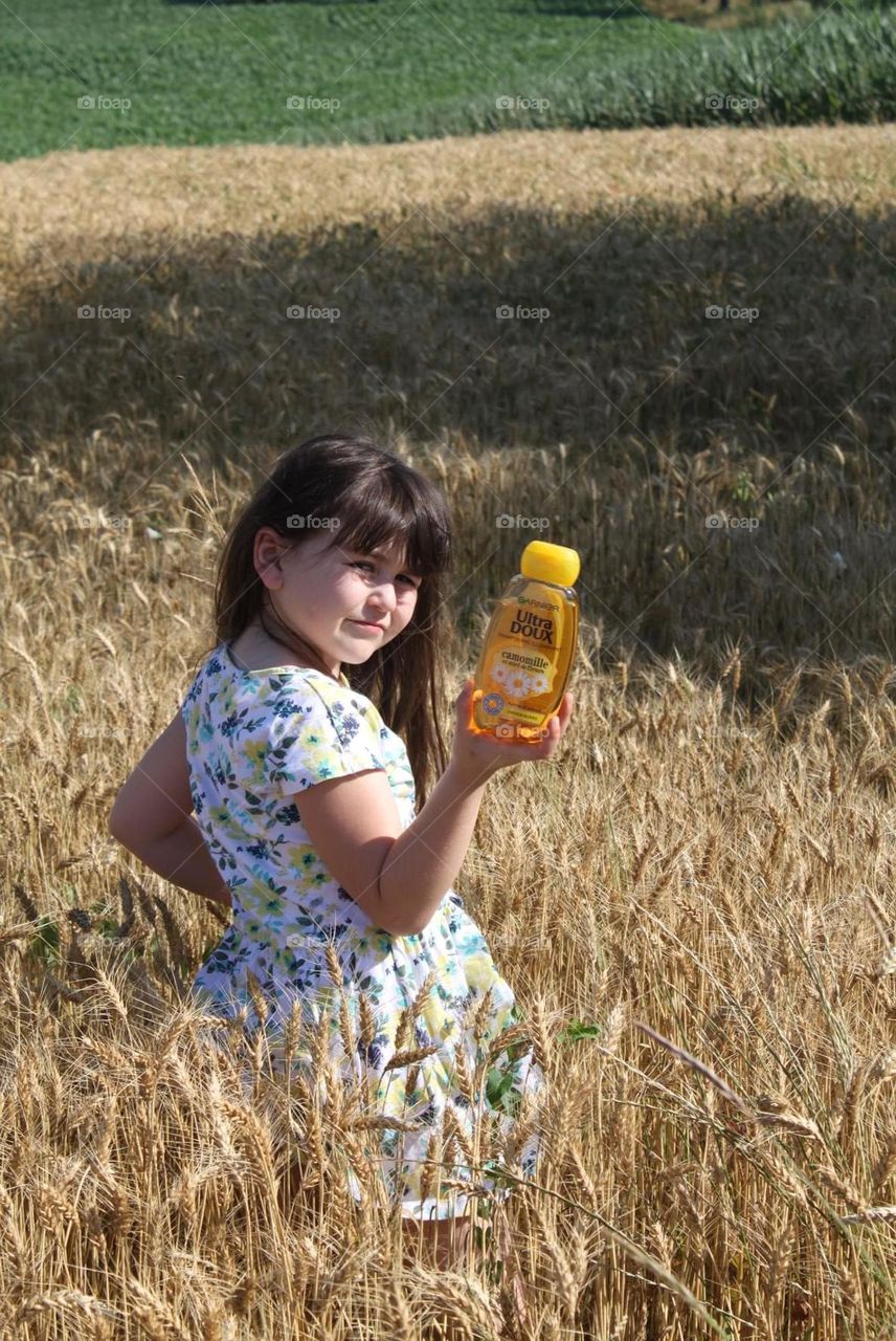 poses in the middle of the wheat