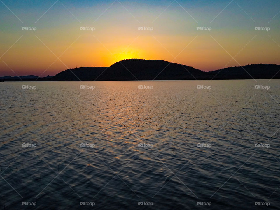 sunset behind a mountain over a lake