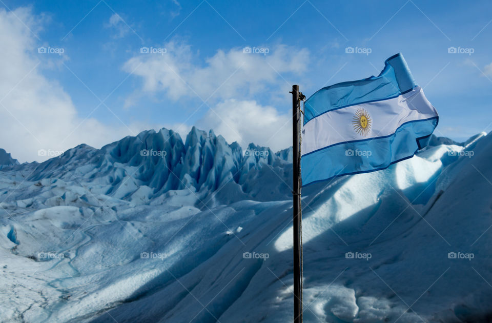 argentina flag behind perito moreno glacier