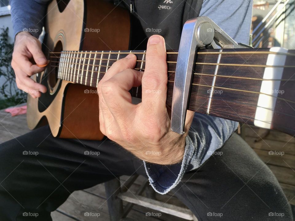 Playing guitar fingers and strings closeup