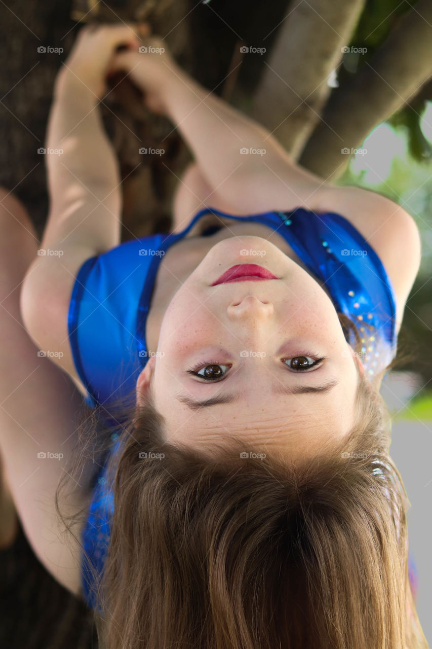 girl upside down in a tree